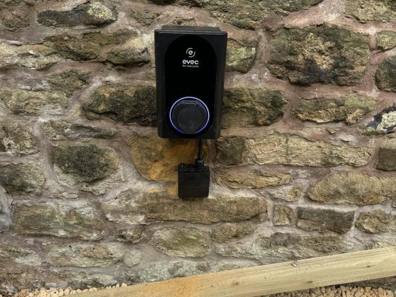 Home EV charger fitted to a stone wall