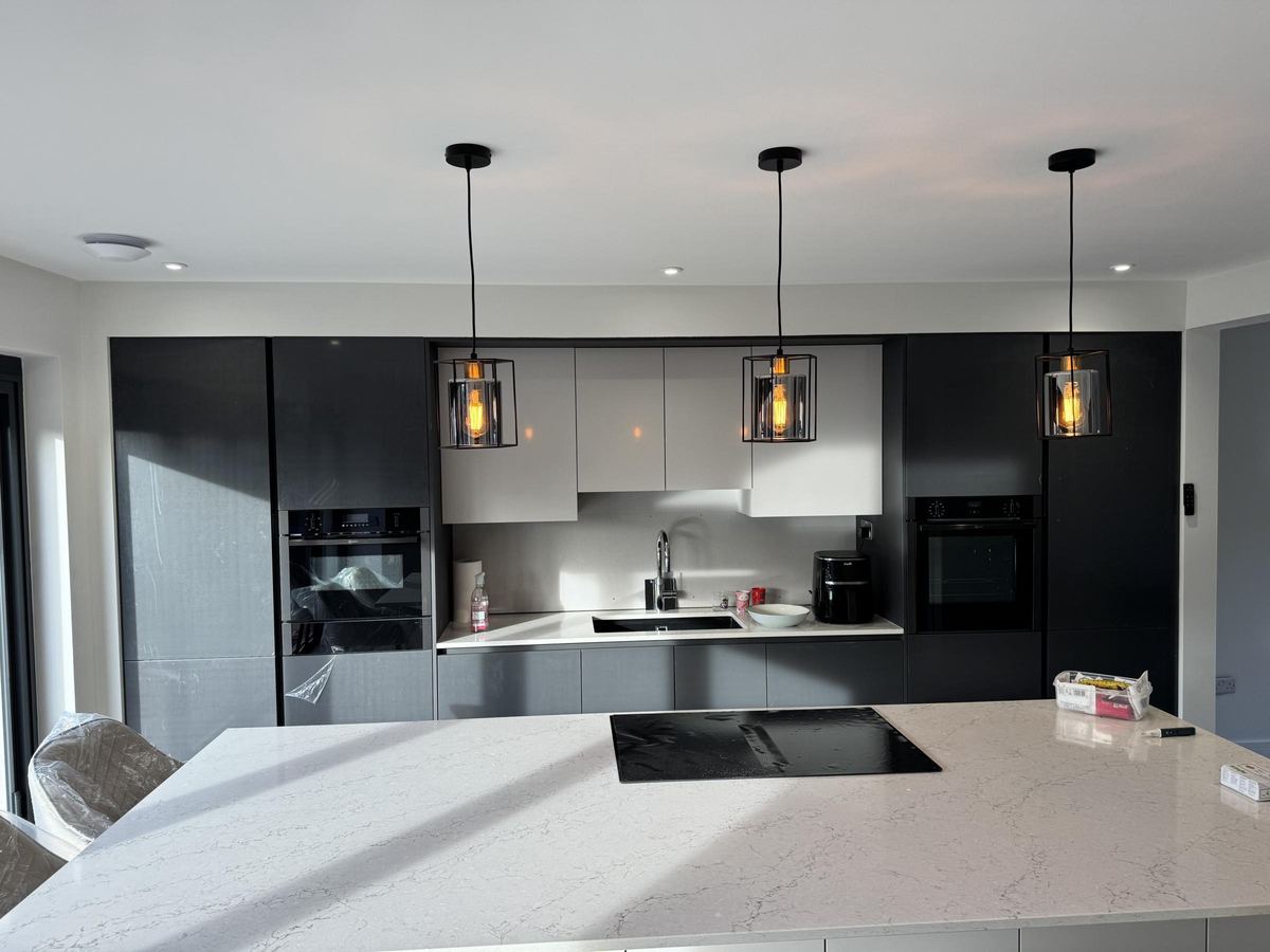Modern kitchen with three lit pendant lights over the island